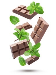 Image of Milk chocolate pieces and mint falling on white background