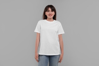 Smiling woman in white t-shirt on grey background