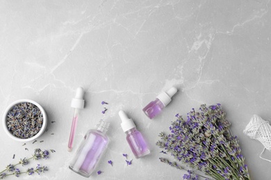 Photo of Flat lay composition with natural lavender essential oil on marble table, space for text