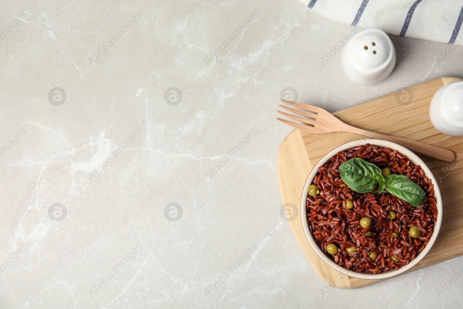 Photo of Flat lay composition with delicious cooked brown rice on white marble table. Space for text