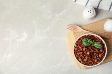 Flat lay composition with delicious cooked brown rice on white marble table. Space for text