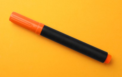 Photo of Bright marker on orange background, top view