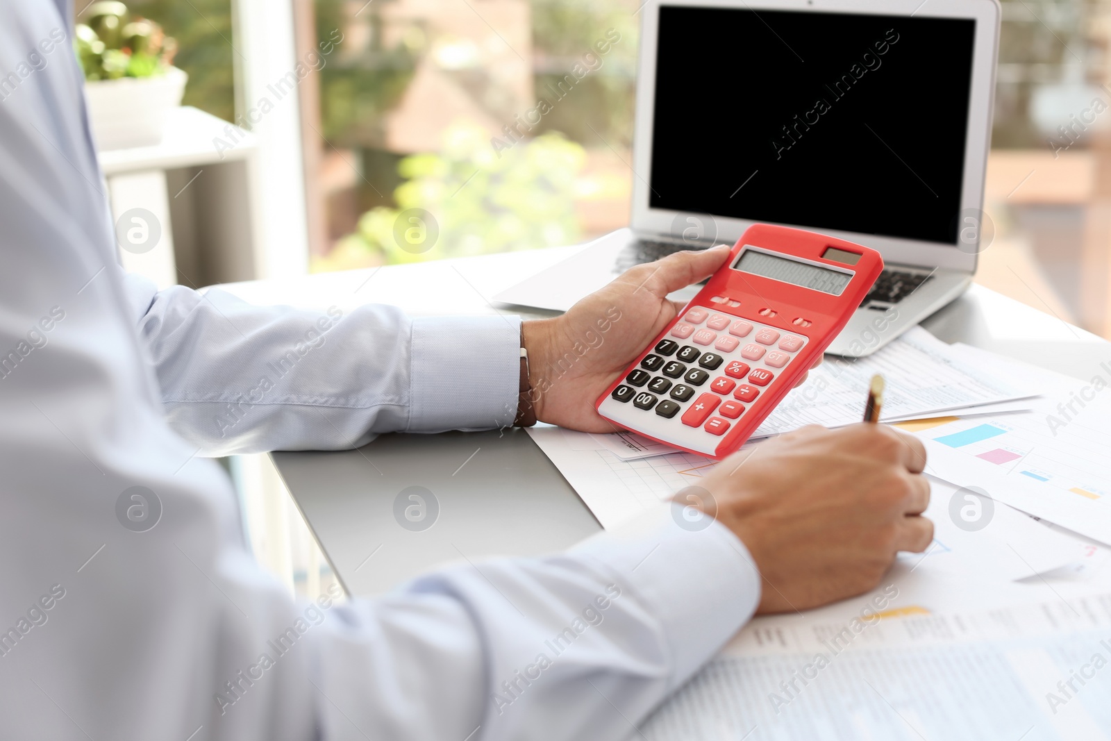 Photo of Tax accountant working with documents at table