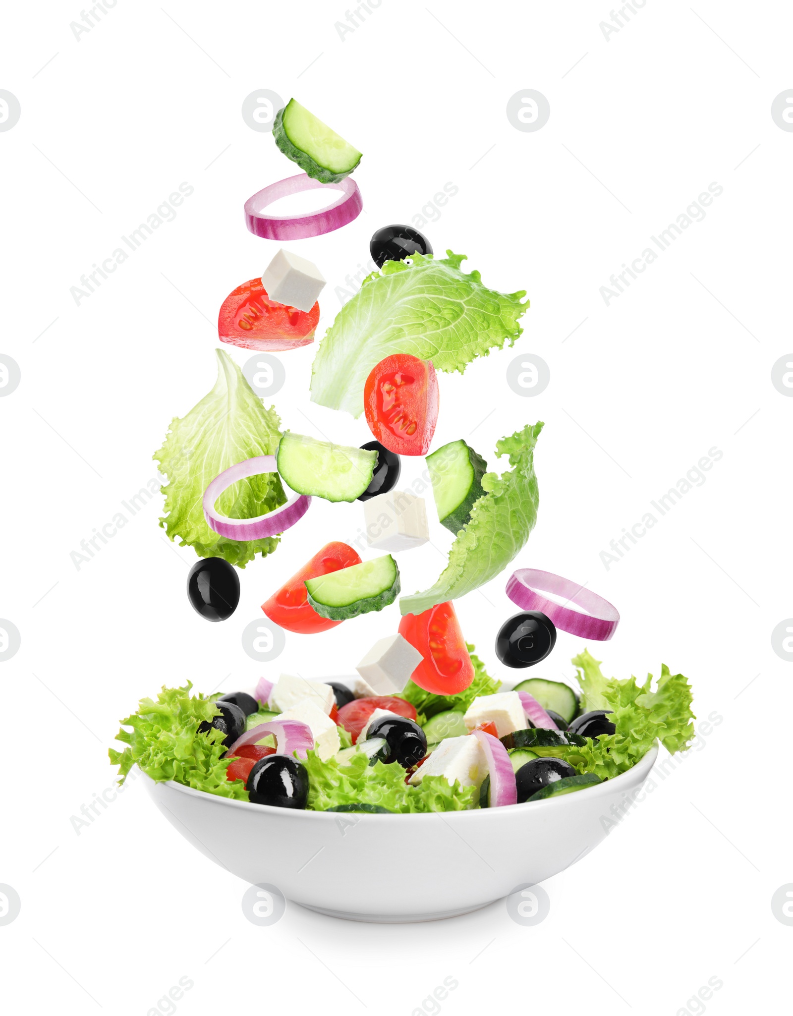 Image of Fresh ingredients for Greek salad falling into bowl on white background