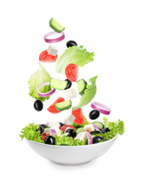 Image of Fresh ingredients for Greek salad falling into bowl on white background