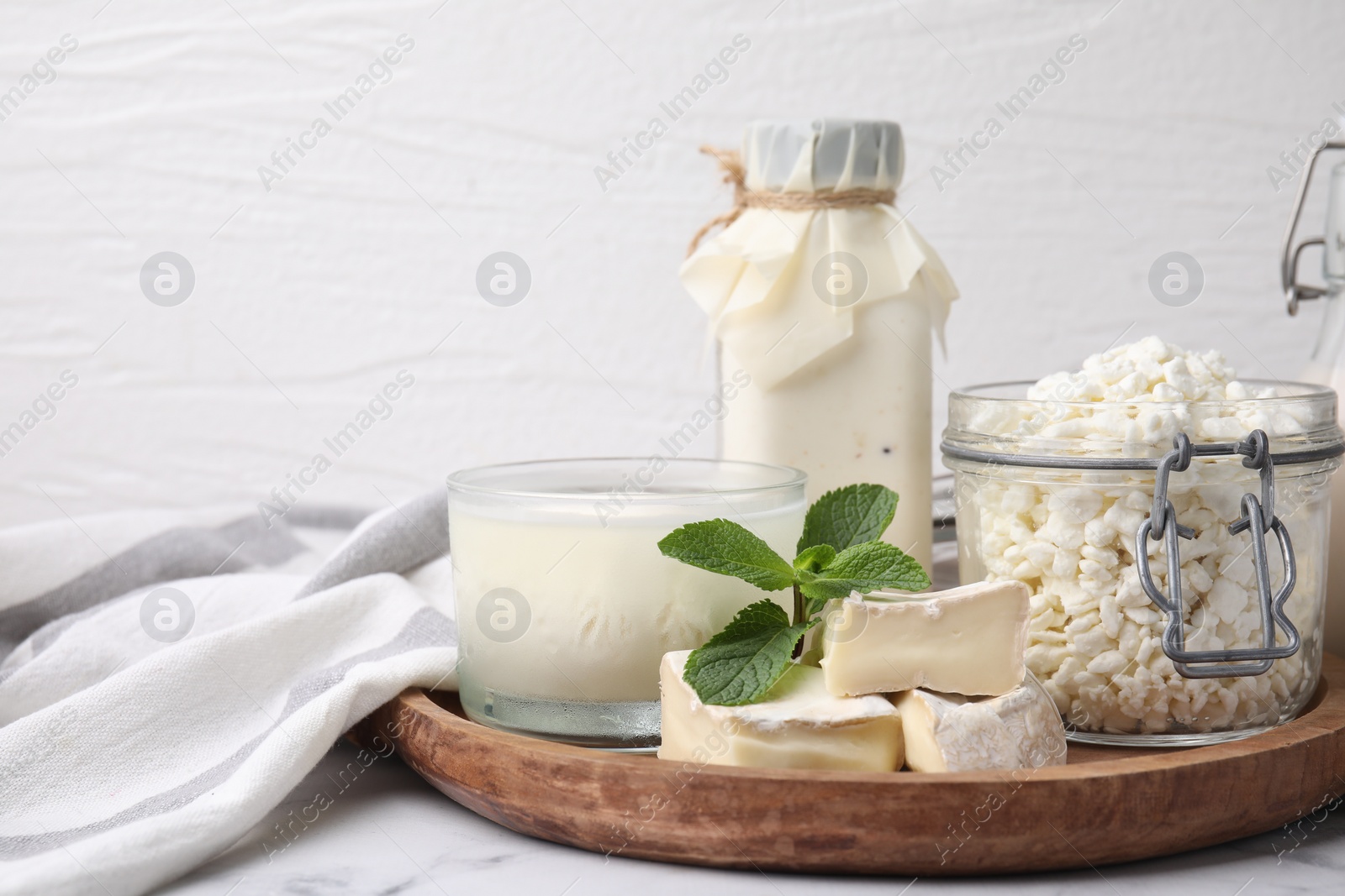 Photo of Different dairy products and mint on white marble table