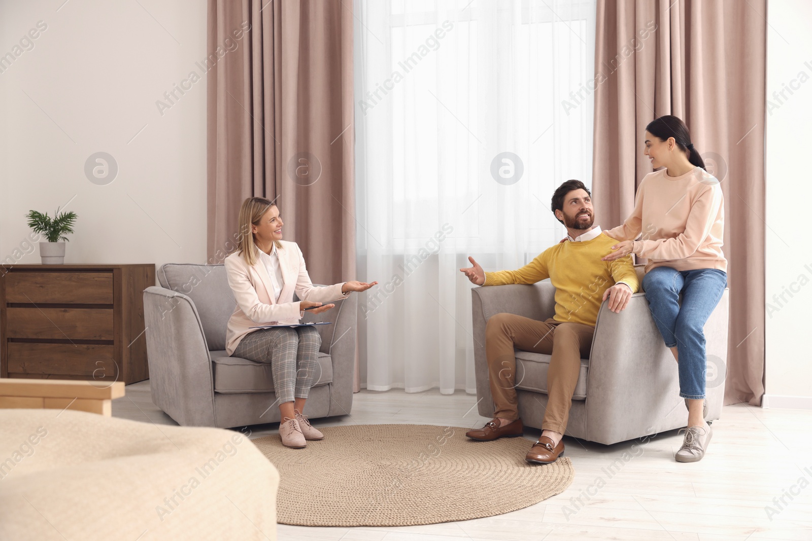 Photo of Real estate agent working with couple in new apartment