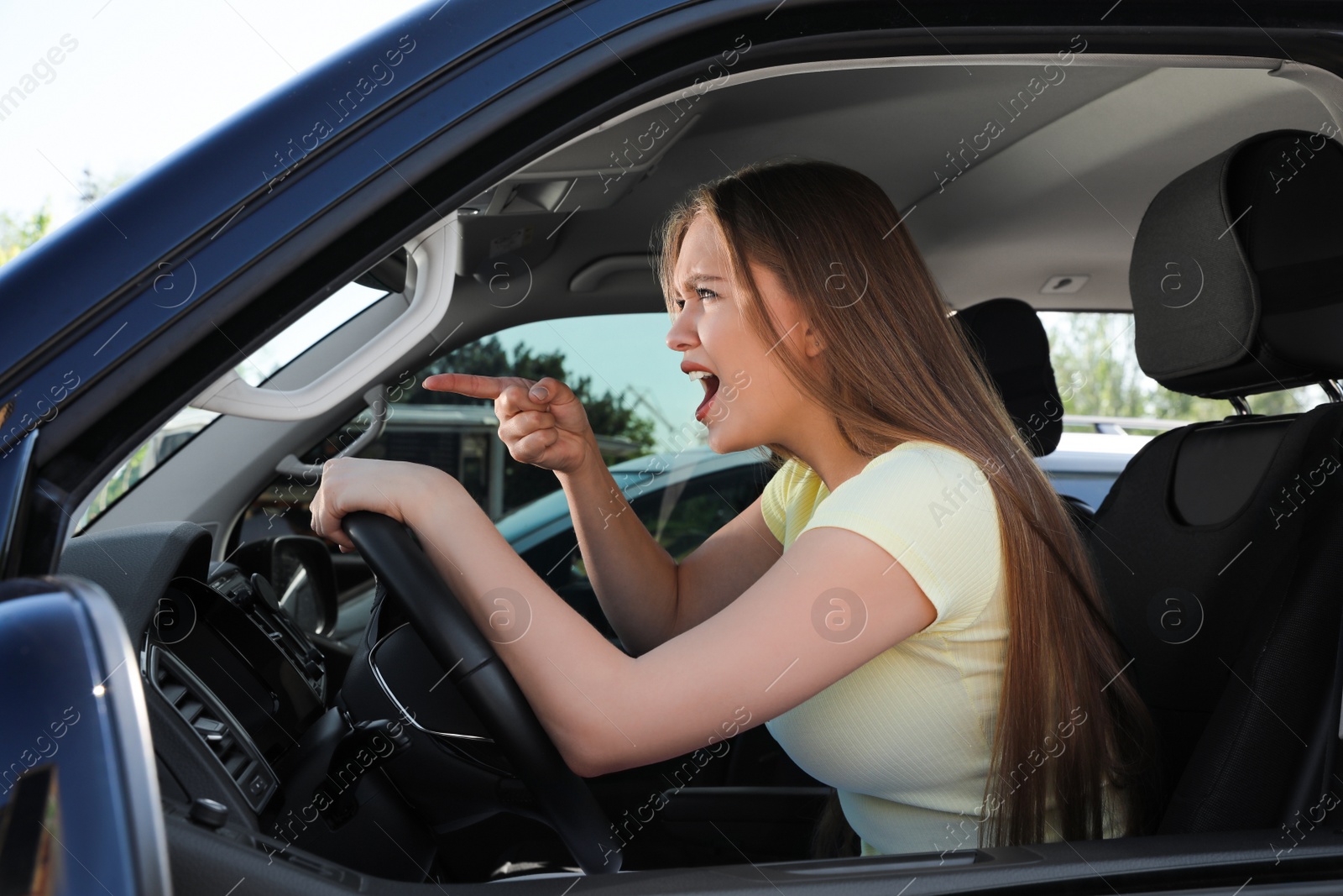 Photo of Emotional woman in car. Aggressive driving behavior