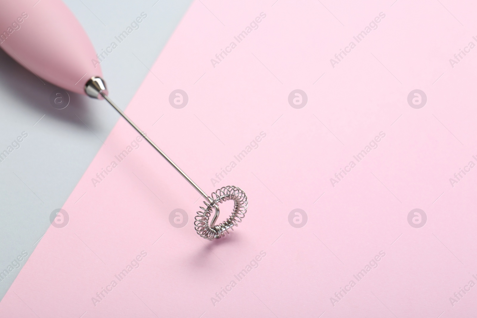 Photo of Pink milk frother wand on color background, space for text