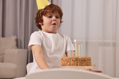 Photo of Cute boy with birthday cake at home