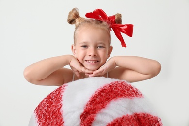 Cute little girl dressed as candy on white background. Christmas suit