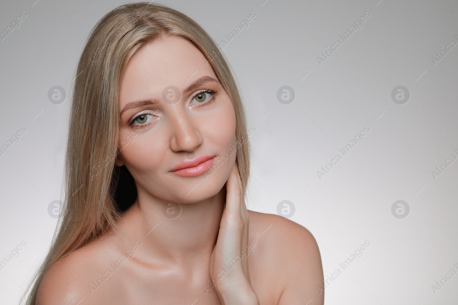 Photo of Portrait of young woman with beautiful face on light grey background. Space for text