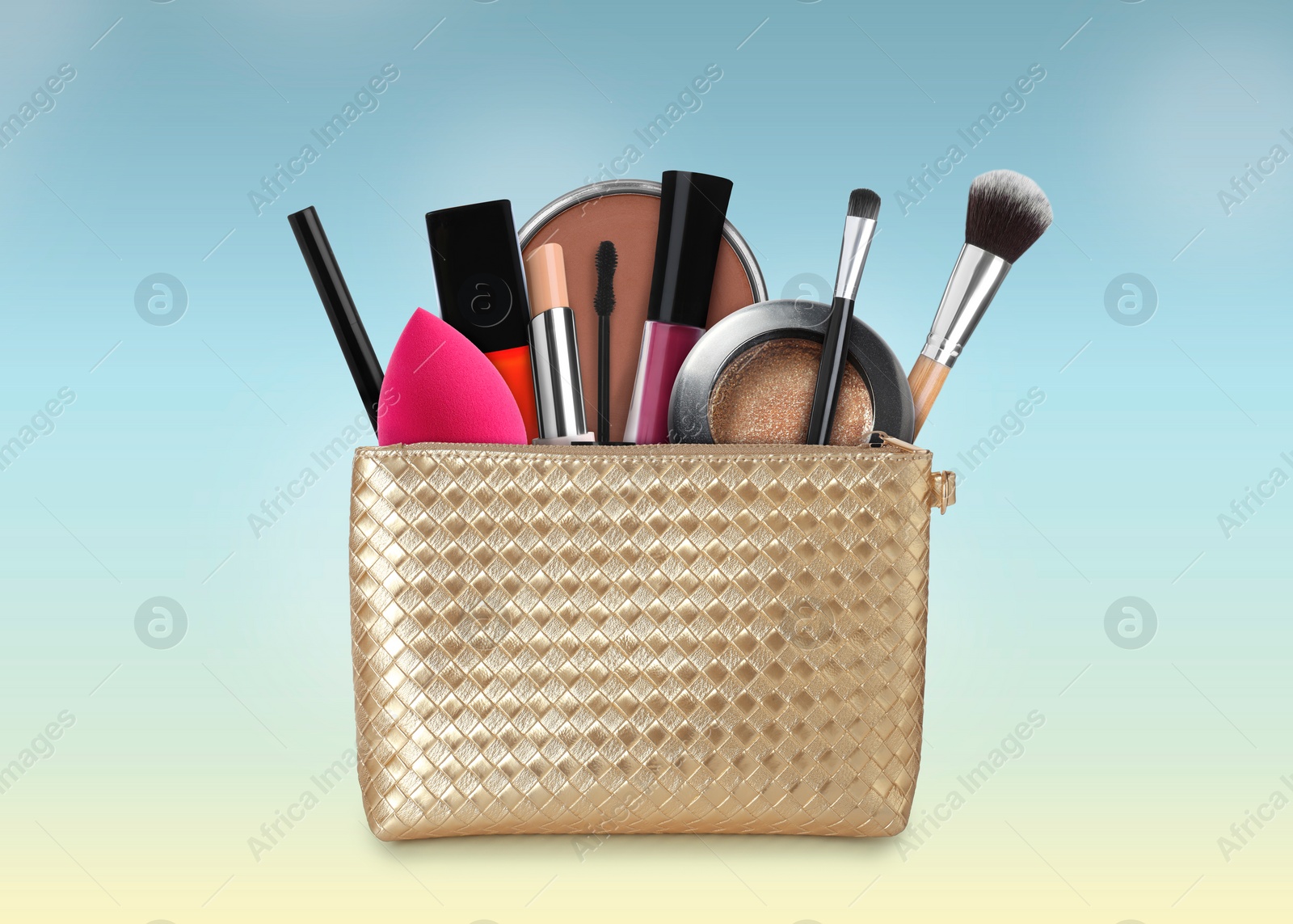 Image of Cosmetic bag filled with makeup products on color gradient background