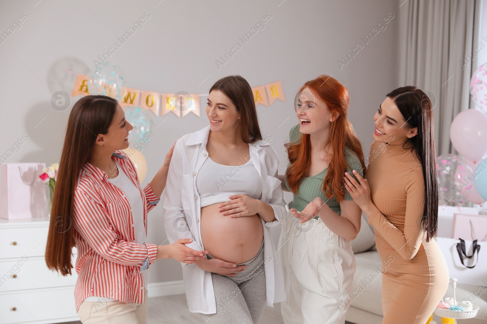 Photo of Happy pregnant woman spending time with friends at baby shower party