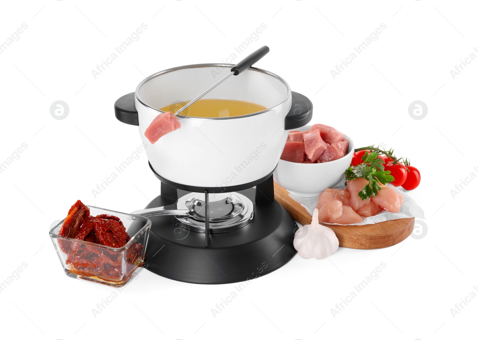 Photo of Fondue pot with oil, fork, raw meat pieces and other products isolated on white