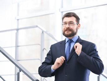 Photo of Portrait of confident mature man in elegant suit on stairs