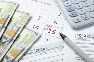 Photo of Calendar with date reminder about tax day, documents, money, pen and calculator, closeup