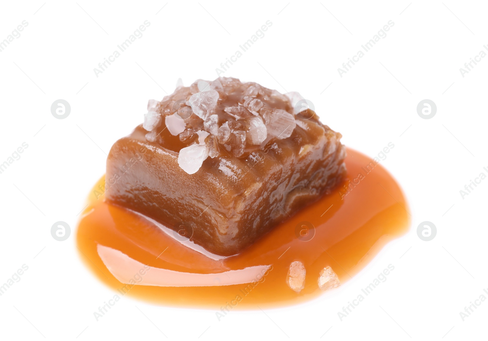 Photo of Delicious salted caramel with sauce on white background