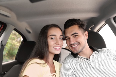 Happy young couple in car on road trip