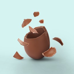 Image of Exploded milk chocolate egg on dusty light blue background