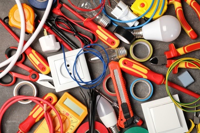 Set of electrician's tools on gray table, top view