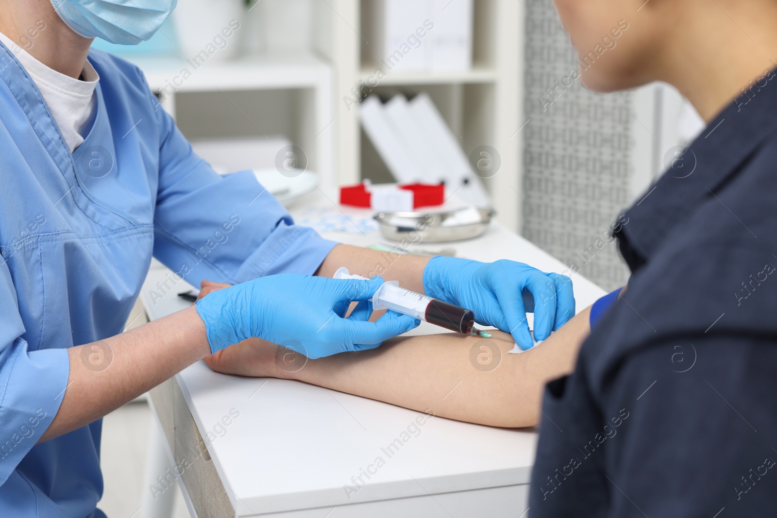 Photo of Laboratory testing. Doctor taking blood sample from patient at white table in hospital, closeup