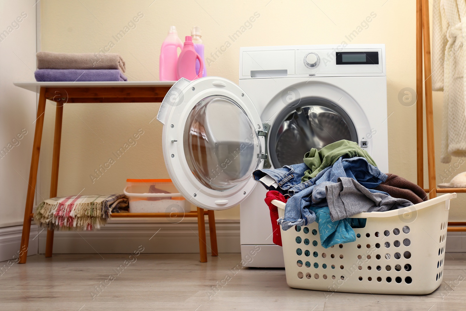 Photo of Stylish interior with modern washing machine and laundry basket