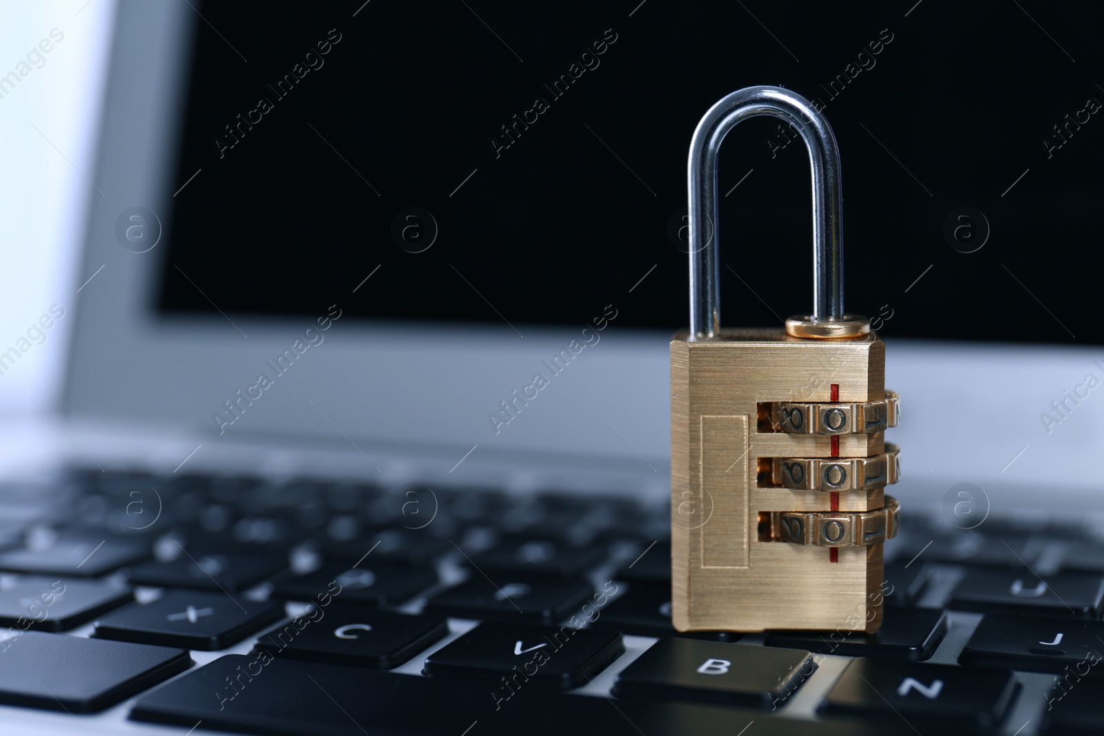 Photo of Metal code padlock on laptop keyboard, space for text. Cyber security concept