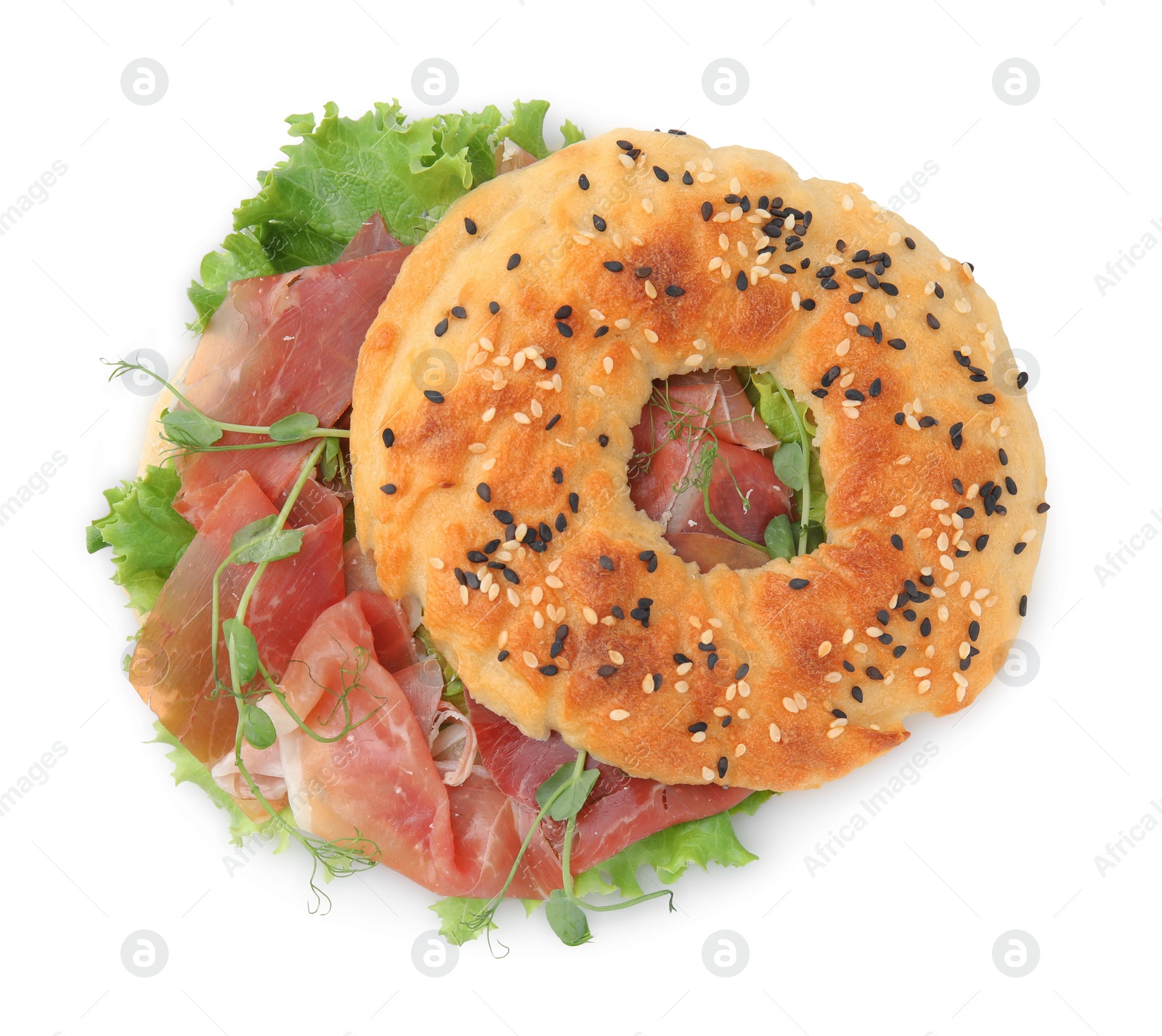 Photo of Tasty bagel with cured ham and lettuce isolated on white, top view