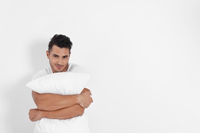 Photo of Young man with soft pillow on white background