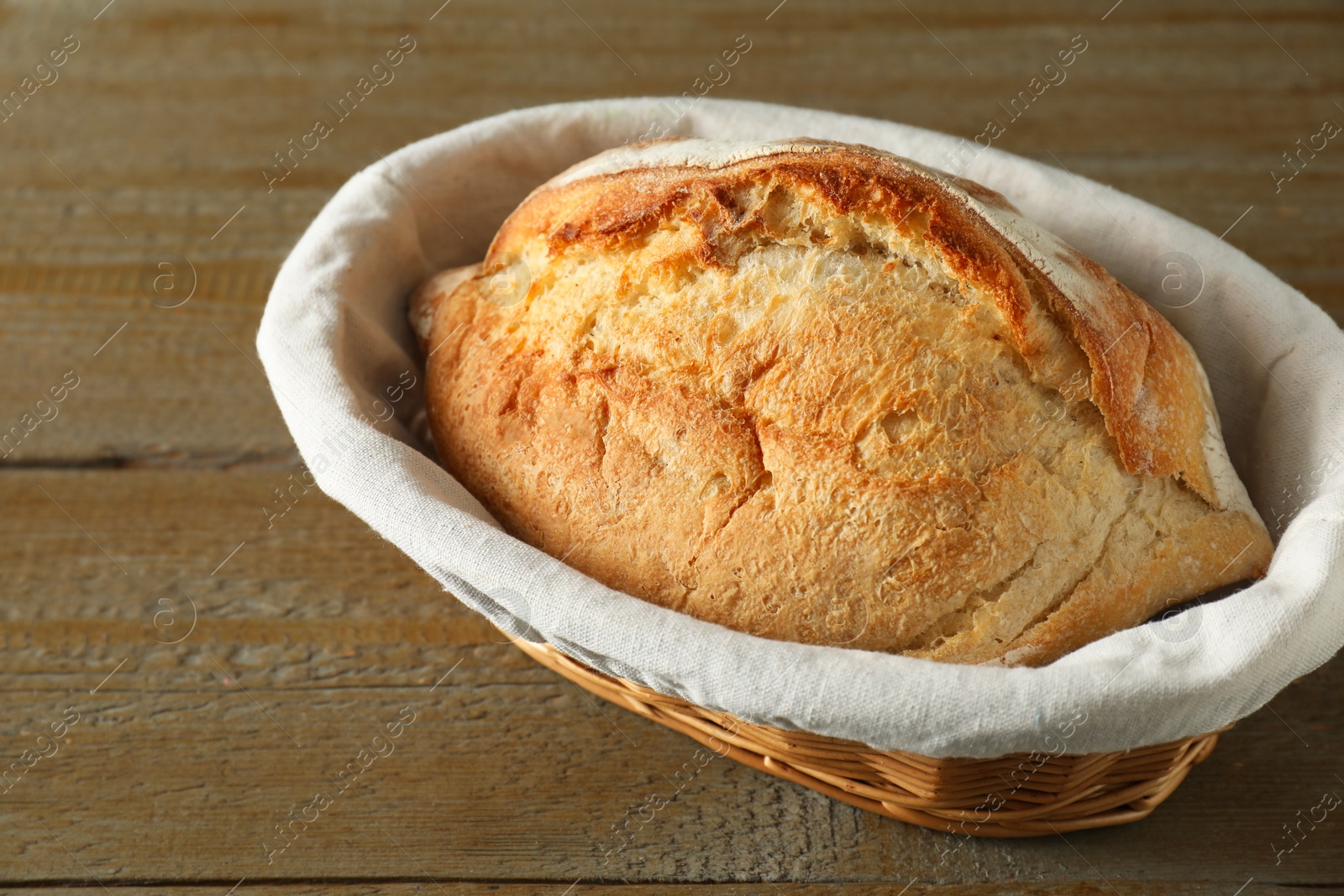 Photo of Basket with fresh bread on wooden table