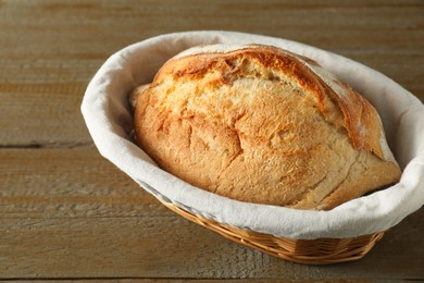 Photo of Basket with fresh bread on wooden table