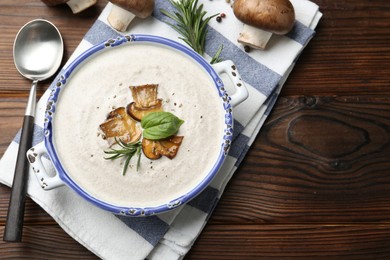 Photo of Delicious homemade mushroom soup served on wooden table, flat lay. Space for text