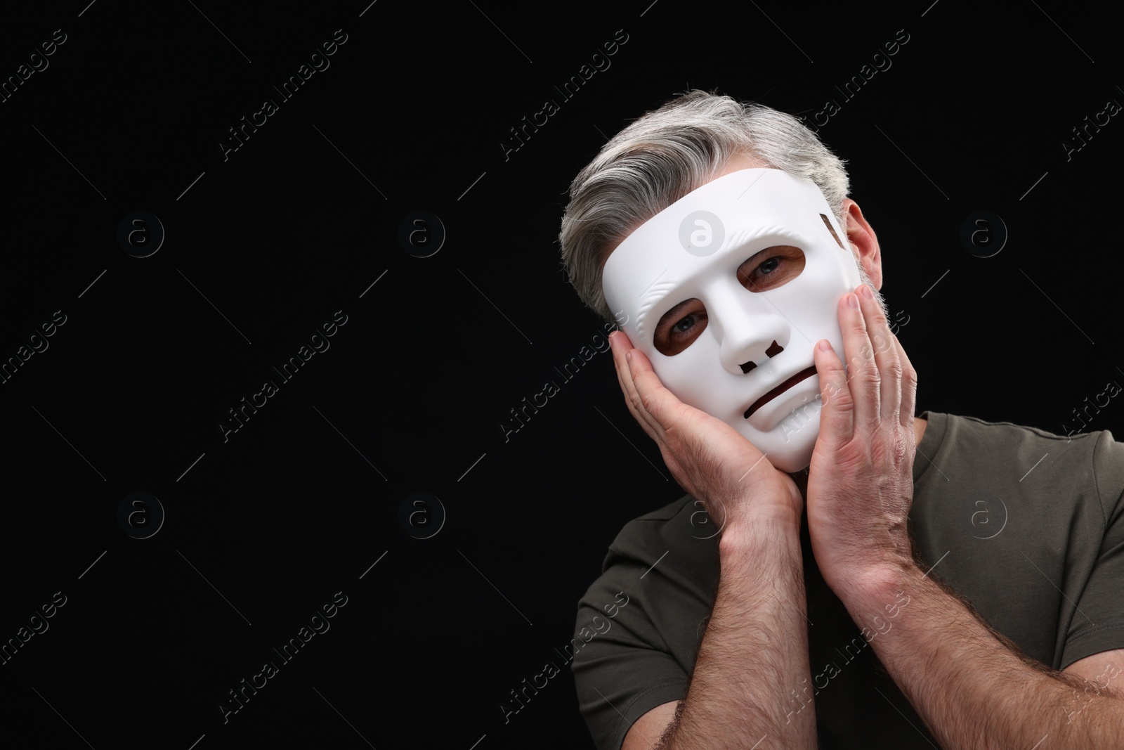 Photo of Multiple personality concept. Man in mask on black background. Space for text