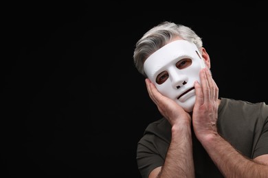 Photo of Multiple personality concept. Man in mask on black background. Space for text