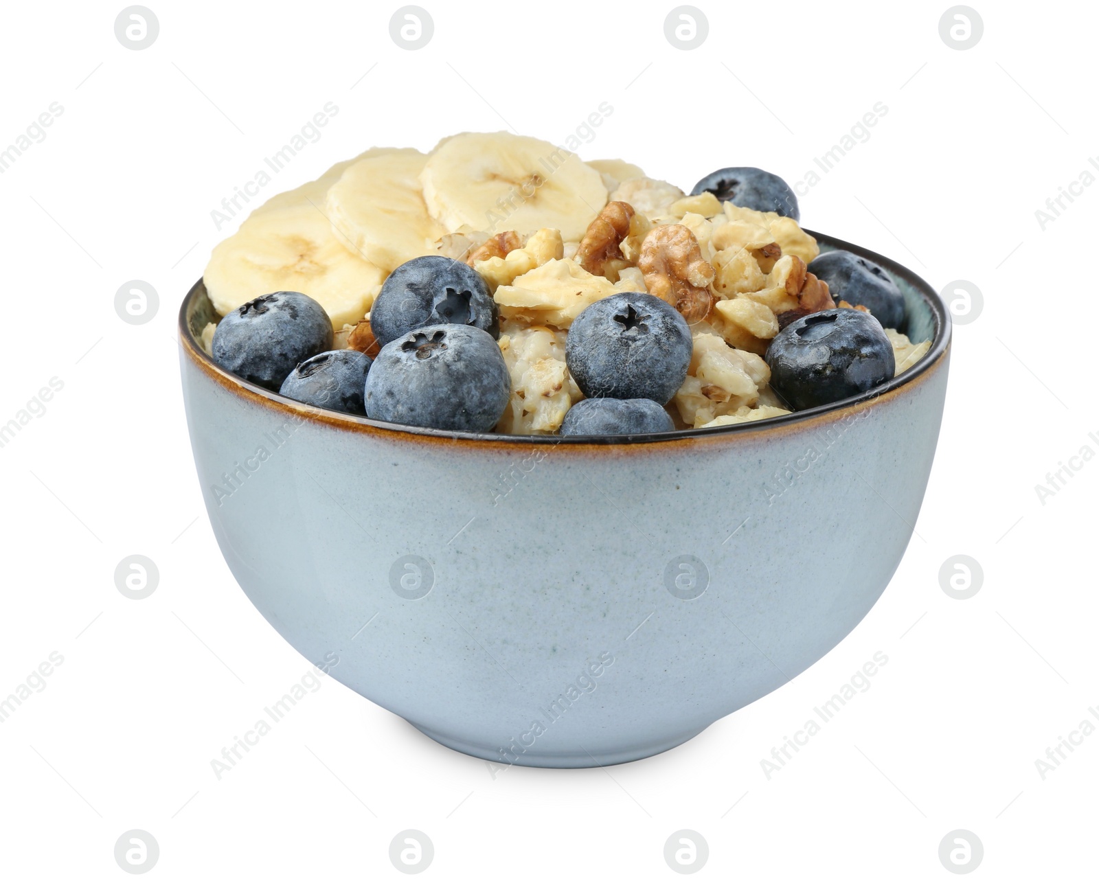 Photo of Tasty oatmeal with banana, blueberries and walnuts in bowl isolated on white