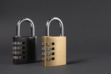 Photo of Steel combination padlocks on dark grey background, closeup. Space for text