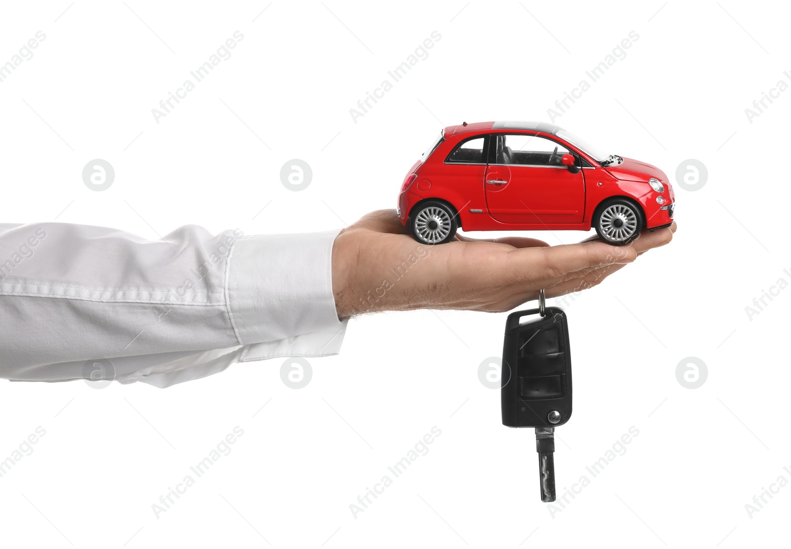 Photo of Man holding key and miniature automobile model on white background, closeup. Car buying