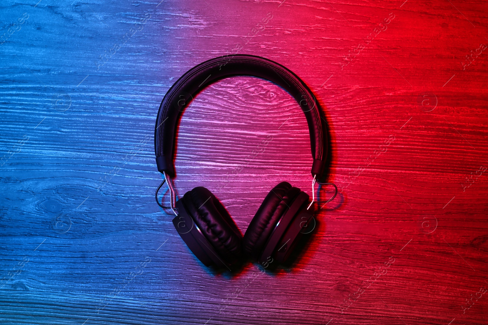 Photo of Stylish headphones on wooden background, top view