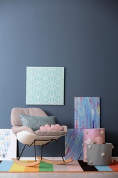 Photo of Modern room interior with comfortable rocking chair and rainbow carpet