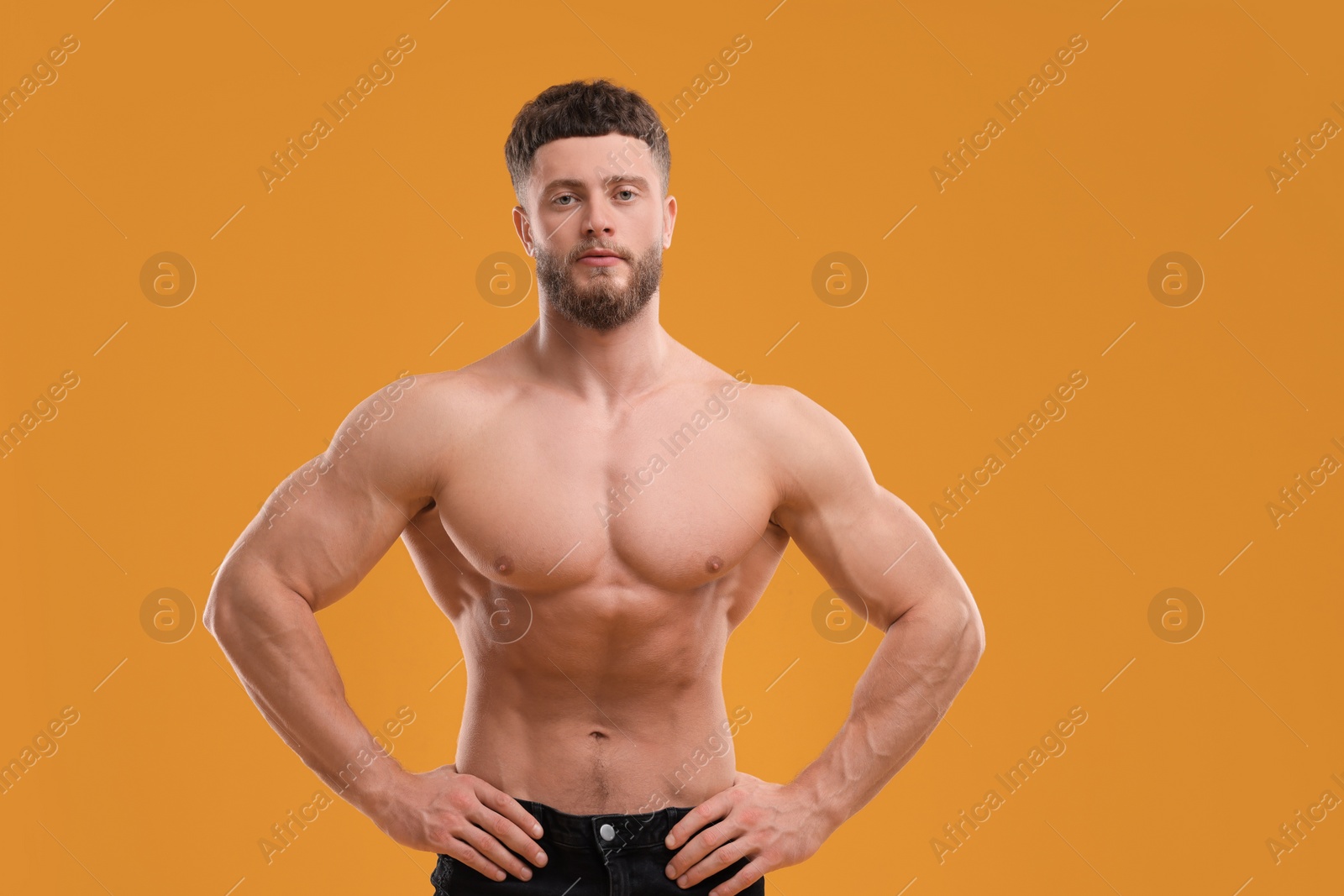 Photo of Handsome muscular man on orange background. Sexy body