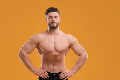 Photo of Handsome muscular man on orange background. Sexy body