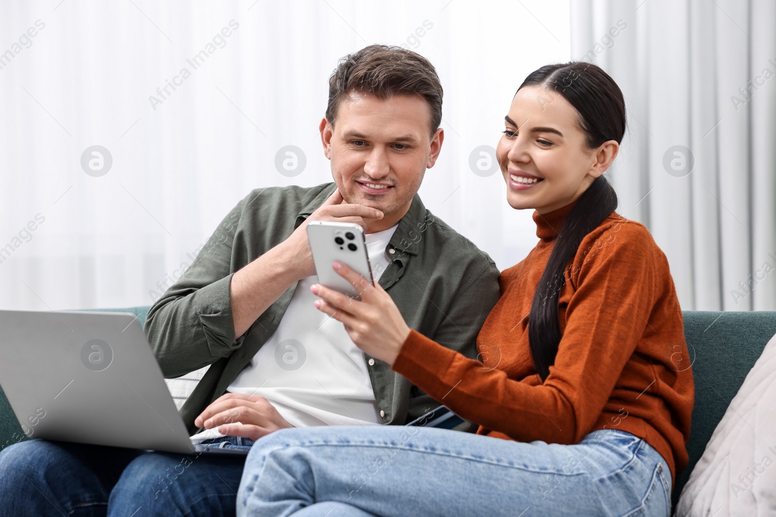 Photo of Happy couple with credit card and gadgets shopping online at home