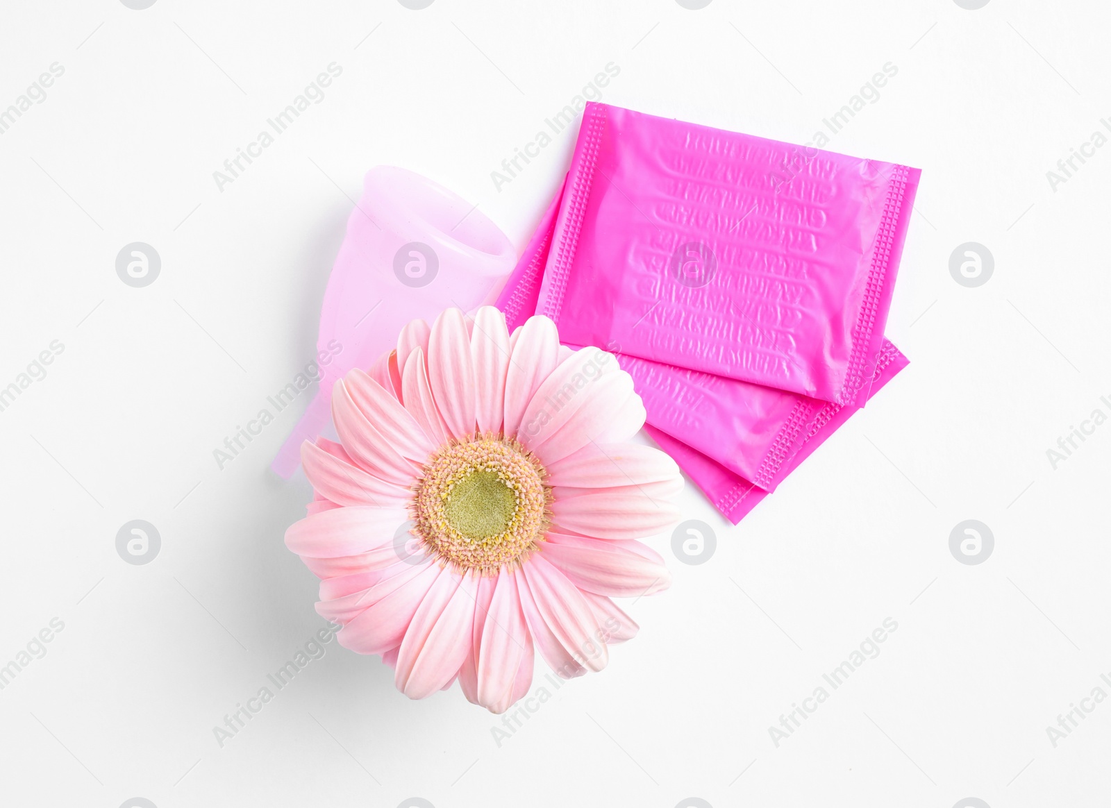 Photo of Menstrual pads and gerbera flower on white background, top view. Gynecological care