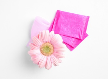 Photo of Menstrual pads and gerbera flower on white background, top view. Gynecological care