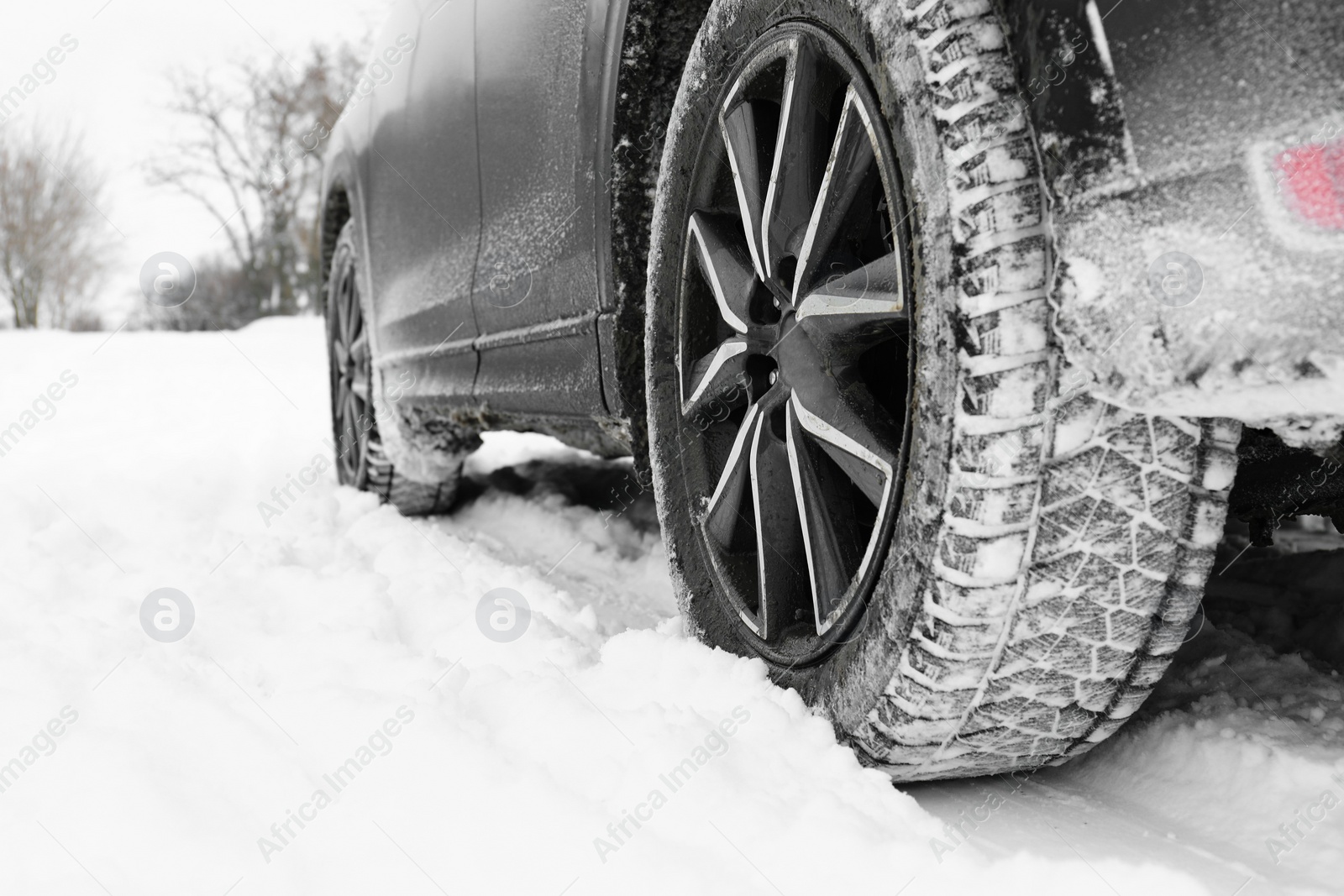 Photo of Snowy country road with car on winter day, closeup