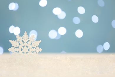 Photo of Beautiful decorative snowflake against blurred festive lights. Space for text