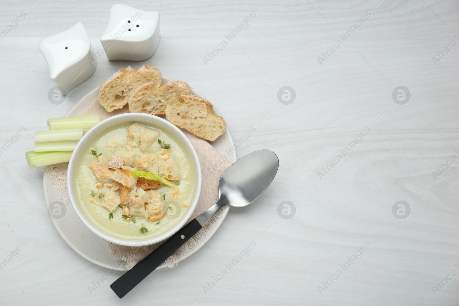 Photo of Delicious celery soup served on white wooden table, flat lay. Space for text