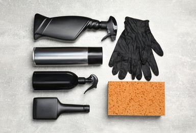 Flat lay composition with car cleaning products, sponge and gloves on light grey table