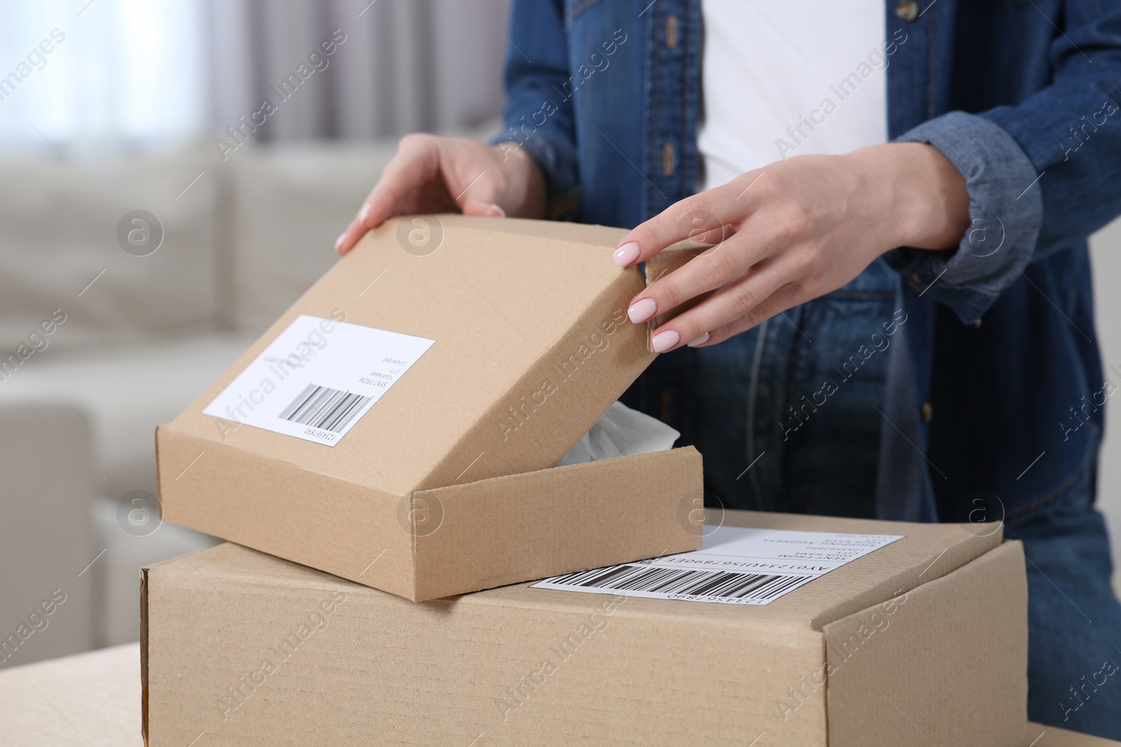 Photo of Woman unpacking parcel at home, closeup. Online store